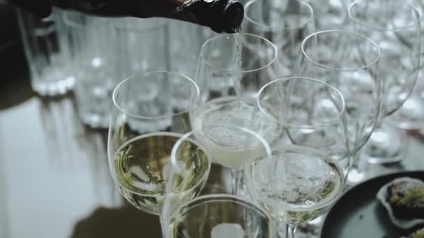 シャンパンをガラスに注いでいる未知のウェイターの手 イベントのメガネでシャンパン 結婚式 ケータリングサービス スローモーションショット 高品質の4K映像 — ストック動画