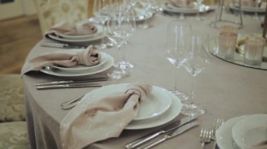 Gelin ve damat, düğün masasına yakın çekim ayarları, altın kenarlı güzel tabaklar mavi masa örtüsü, masanın üzerinde güneş ışığı, yavaş çekim. Yüksek kalite 4k görüntü