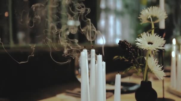 蜡烛当装饰品 蜡烛冒出的烟 餐厅里蜡烛旁边的花朵组成 动作缓慢 高质量的4K镜头 — 图库视频影像
