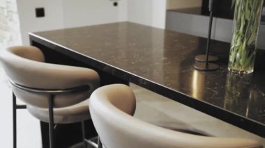 Interior Empty Modern Loft Office. Fashionable armchairs upholstered in gray leather and with metal legs stand next to a black table, slow motion. High quality 4k footage
