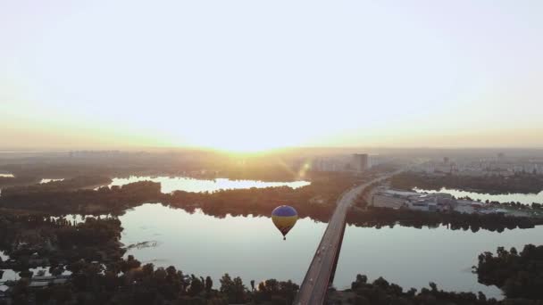 基辅上空的热气球在日出时从桥上升起 俯瞰第聂伯河 城市美丽的全景 蓝色和黄色的气球 是的高质量的4K镜头 — 图库视频影像