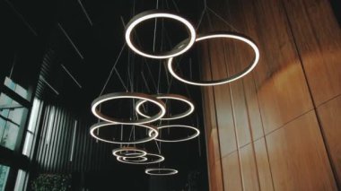 Lobideki modern avize tavandan sarkıyor. Bir otel ya da restoran salonu, avize yavaş çekimde kamerayı açtı. Yüksek kalite 4k görüntü