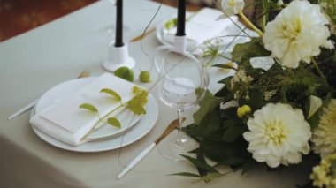 Top view of beautiful wedding decor, all decorated in white, green colors style. Classic served plates and golden forks on the table. camera moving slow motion. . High quality 4k footage
