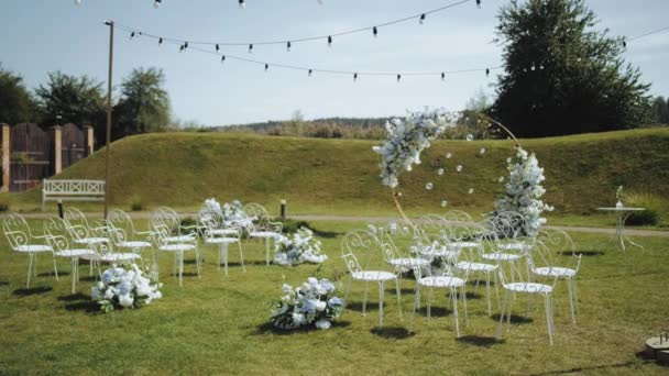 婚礼拱形装饰侧视图 白色和蓝色花朵装饰 白色金属椅子和灯具动作缓慢 婚外仪式 高质量的4K镜头 — 图库视频影像