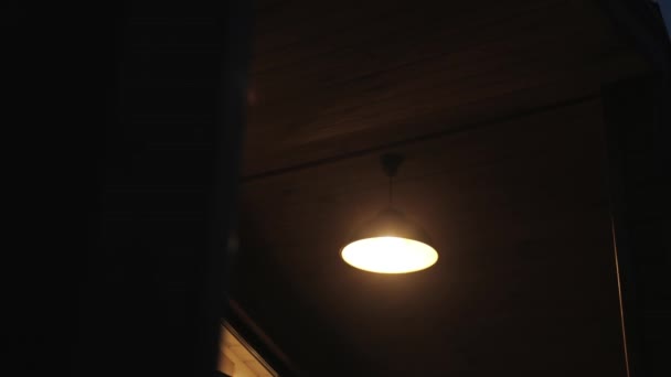 Μόνος Ηλεκτρικό Λαμπτήρα Δίνει Ζεστό Φως Στην Εξωτερική Βεράντα Του — Αρχείο Βίντεο