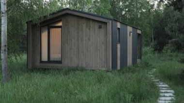 Ahşap İskandinav evi pencerenin ışığı yanıyor, ormanın ortasında sessiz bir orman kulübesi, evin yakınında yapayalnız huş ağacı. Turist evi, av evi, ahşap bina. 4k görüntü