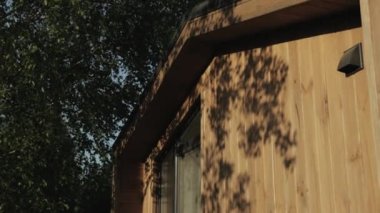 Tahta ev kamerasının ahşap duvarındaki yaprakların yakın plan gölgesi ileri doğru hareket ediyor, ahşap evin bir parçası, ahşap dokular, arka planlar, ahşap malzeme, ağır çekim. Yüksek kalite 4k görüntü