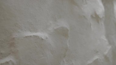 Düz olmayan duvar, kabaca bembeyaz, düz, dokulu duvar, yavaş çekim. Yüksek kalite 4k görüntü