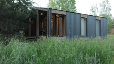 Sabah ormanlarında küçük bir kulübe, evin önünde uzun otlar, sabahları bulutlu bir hava. Konforlu ahşap ev, ağır çekim. Yüksek kalite 4k görüntü