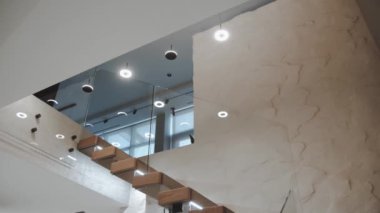 Avizeler ve birçok yuvarlak lambalar evin içindeki merdivenlerden tavana asılıyor. İki katlı bir dairede merdivenlerden lamba asmak, lambaları yakmak, ağır çekimde bebek çekimi. Yüksek kalite 4k görüntü