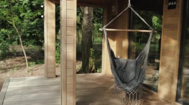Evin yakınındaki ahşap bir verandada bir hamak asılı. Güzel teras..