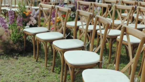 Rząd Drewnianych Krzeseł Umieszczonych Tętniącym Życiem Zielonym Polu Trawiastym Tworzących — Wideo stockowe