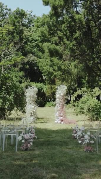 ヴァルティカルビデオ 結婚式の結婚式は 木々に囲まれた自然の景観を持つ公園に設定されています 緑豊かな草がお祝いのための絵のような設定を作成します — ストック動画