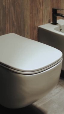 Minimal stil modern pastel parlak banyo ve banyoda ışıklandırma. Beyaz banyo seramik fayans zeminde ağır çekimde. Yüksek kalite 4K görüntü. Dikey video