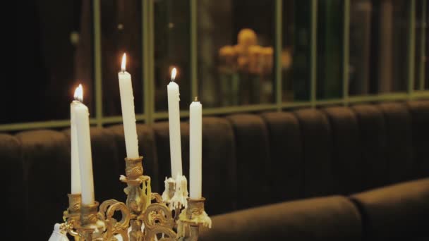 木制桌子上的烛台上点燃了几支蜡烛 用温暖的火焰照亮了房间 室内设计为比赛营造了舒适的气氛 — 图库视频影像