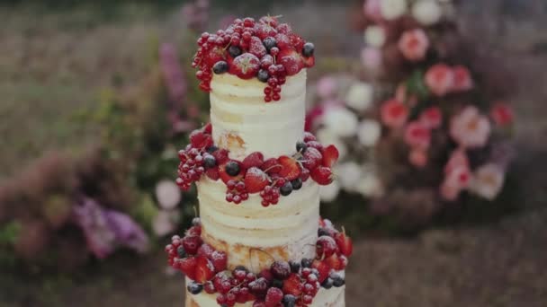 一个精美的结婚蛋糕 装饰着新鲜的浆果 周围是明亮的花束和花束 创造了一个美丽而艺术的展示 — 图库视频影像