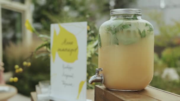 新鮮なレモン 水から作られたレモネードの瓶は素朴な木製のテーブルの上に置かれ 夏のイベントで提供される準備ができています — ストック動画
