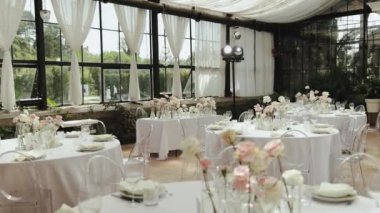 Güzel cam bir mekanda zarif bir çiçek dekoru olan zarif bir düğün resepsiyonu, aşkı kutlamak için mükemmel.