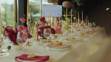 Çok güzel düzenlenmiş bir yemek masası. Canlı çiçekler ve özel bir etkinlik için parlayan mumlarla süslenmiş.