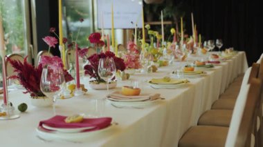 Çiçekler, mumlar ve nefis yemek takımlarıyla dolu güzel bir masa. Şatafatlı etkinlikler ve kutlamalar için mükemmel.