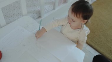 Genç bir çocuk, yaratıcılığını arttıran ve motor becerilerini geliştiren çizimlere derinden odaklanır.