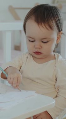 Genç bir çocuk derinden çizim yapmaya, yaratıcılığını göstermeye ve erken öğrenmeyi samimi bir ortamda sergilemeye odaklanır.