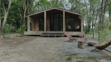 Gerçekten huzurlu ve rahatlatıcı bir kaçış için ideal, yemyeşil ağaçların arasına yerleştirilmiş tuhaf, sakin bir ahşap kulübe.