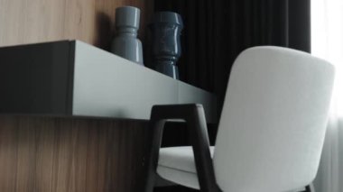 Şık minimalist sandalyesi ve zarif vazoları olan modern bir çalışma alanı çarpıcı bir çağdaş görünüm yaratır.