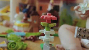 Canlı ve renkli bir LEGO çiçek kulesi yaratıcılığı ve sonsuz eğlenceyi gösteren neşeli bir ortamda kurulmuş.