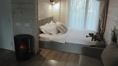 Bu, yumuşak çarşafları barındıran huzurlu ve modern bir yatak odası. Rahatlamak için sıcak ve davetkar bir atmosfer yaratıyor.