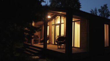 Geceleri güzelce aydınlatılan büyüleyici, modern bir kulübe, doğaya yerleşmiş, huzur ve huzur sunuyor.