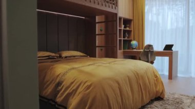 Bu modern yatak odasında canlı sarı yatak odası, şık bir masa ve rahat bir atmosfer için zarif bir dekor var.
