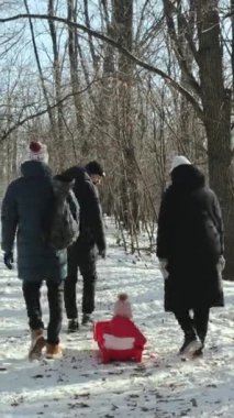 Aileler muhteşem bir kış gününün keyfini çıkarırlar, kızak kullanırken neşeyle yürürler ve karla kaplı ağaçları keşfederler. Dikey video