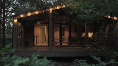 Huzurlu ormanlarda yuva yapmış, parıldayan ışıklarla hafifçe aydınlatılan, gerçekten sakin bir atmosfer yaratan rahat bir kulübe.