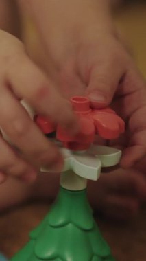 Bir çocuğun renkli bir oyuncak çiçekle neşeli bir şekilde oynadığı dikey video yaratıcılığı teşvik ediyor ve motor becerilerini geliştiriyor.