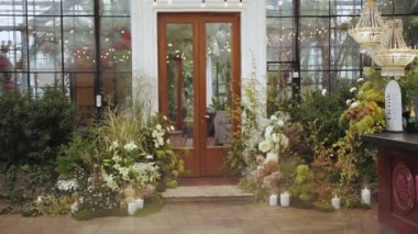 Seranın girişindeki canlı çiçeklerin ve yemyeşil çimlerin çok güzel bir düzeni var.