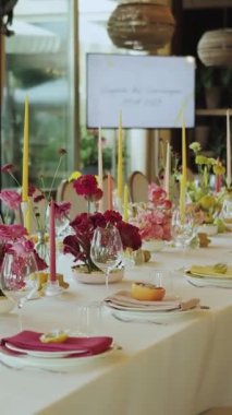 Dikey video güzel düzenlenmiş bir yemek masası zarif bir dekor, çarpıcı çiçek süslemeleri ve sıcak bir ortam içeriyor.