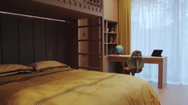 Verimlilik için şık ve verimli bir çalışma alanının yanında rahat bir yatak odası sunan rahat ve modern bir yatak odası.