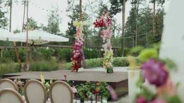 Göz kamaştırıcı ve zarif bir açık hava düğün sahnesi. Canlı çiçek süslemeleri ve geniş koltuklarla süslenmiş.