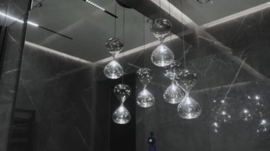 Şık ve güzel tasarlanmış cam kum saati şeklindeki kolye ışıkları çağdaş bir yaşam alanını güçlendiriyor.