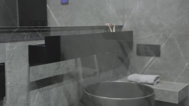 Bu şık banyo vitrinleri çağdaş armatürlerle birlikte parlak gri fayanslar sergiliyor, sofistike bir estetik yaratıyor.