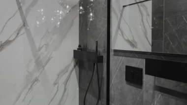 Bu şık banyo gösterişli mermer fayanslar ve lüks bir his için modern duş donanımları içeriyor.