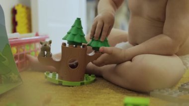 Genç bir çocuk, yerde canlı ve renkli bir oyuncakla yaratıcı bir oyun oynuyor.