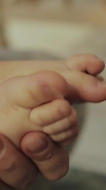 Sevgi dolu bir ebeveyn bebeğini nazikçe kucağına alır derin aşkı ve bakımı sembolize eder. Dikey video.