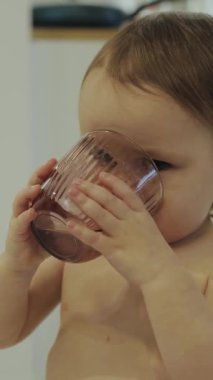 Meraklı ve şakacı bir çocuk çocukluk anılarının masumiyetini gösteren bir içkinin keyfini çıkarıyor. Dikey video.