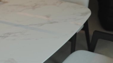 Çağdaş yemek alanları için mükemmel, zarif, modern sandalyelerle süslü, şık bir mermer masa.