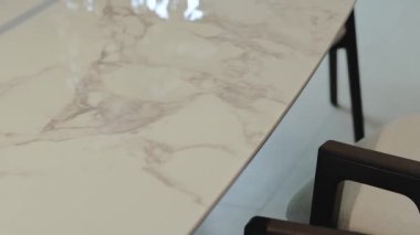 Bu şık mermer masa, çağdaş bir ortamda kurulmuş parlak ve modern sandalyelerle güzelce eşleştirilmiştir.