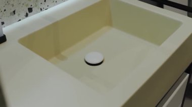 Bu şık mutfak lavabosu minimalist bir tasarım sergiliyor ve verimlilik için uygun bir merkezi drenaj içeriyor.