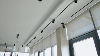 Şık ve çağdaş bir iç mekan. Parça ışıklarının yanı sıra aksan olarak parlak pencere perdeleri sergiliyor.