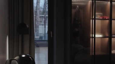 Çağdaş bir yaşam alanı rahat ve rahat bir ortam için şık bir cam dolap ve yumuşak ışıklandırma içerir.